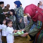 Khofifah Indar Parawansa memberikan kue kepada anak-anak. Foto: humas pemprov Jatim