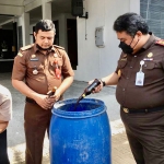 Kepala Kejari Kabupaten Kediri Dedy Priyo Handoyo saat memasukkan barang bukti berupa miras ke dalam tong. Foto: Ist.