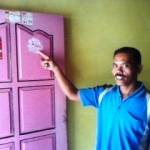 Suparwan menunjukan bekas sobekan stiker di pintu rumahnya. Foto: aris yudi santoso/BANGSAONLINE