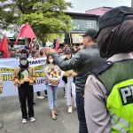Massa aksi yang tergabung dalam Forum Masyarakat Blitar Raya (FMBR), saat memberikan rangkaian bunga untuk Kapolres Blitar Kota,  AKBP Argowiyono, Senin (6/2/2023).