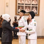 Gubernur Khofifah saat menyematkan pin dan menyerahkan piagam secara simbolis kepada 2 perwakilan Purna-Paskibraka Duta Pancasila Jawa Timur.