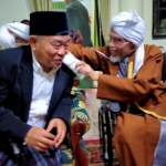 Tuan Guru Haji (TGH) Lalu Turmudzi Badaruddin mengalungkan sorban kepada Prof Dr KH Asep Saifuddin Chalim, MA di  Pondok Pesantren Qomarul Huda, Bagu, Lombok Tengah NTB , Rabu (13/10/2021). foto: mma/ bangsaonline.com