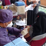 Petugas saat menyuntikkan vaksin kepada salah satu siswi SMKN 3 Kota Kediri. (foto: ist)