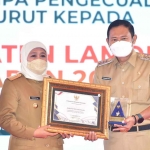 Gubernur Jawa Timur, Khofifah Indar Parawansa, saat menyerahkan penghargaan Opini WTP kepada Bupati Lamongan, Yuhronur Efendi.