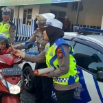 Pengguna jalan saat mendapat coklat karena tertib berlalu lintas oleh petugas dari Polres Kediri Kota . Foto: Ist
