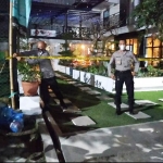 Petugas memasang garis polisi terhadap salah satu cafe di Kecamatan Kanigoro karena beroperasi melanggar jam malam selama PPKM Darurat.