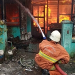 Tim Pemadam Kebakaran Kota Surabaya saat memadamkan api di Jalan Bogen Gang III No 7, Surabaya.