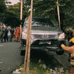 Petugas saat mengevakuasi mobil yang masuk ke kali di Surabaya.