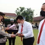 Kapolres Mojokerto Kota, AKBP Wiwit Adisatria, saat memberi penghargaan kepada personel yang berprestasi.