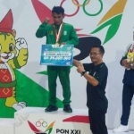 Atlet asal Gresik, Dwi Samsul Arifin (tengah) saat menerima medali emas di PON XXI Aceh-Sumut tahun 2024. FOTO: ist.