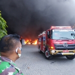 Pihak keamanan dan mobil pemadam yang berusaha memadamkan api. foto: TRIWI YOGA/ BANGSAONLINE