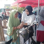 Mimik Idayana menyapa seorang nenek di sela membagikan makanan gratis. Foto: Ist