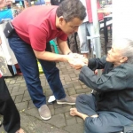 Wan Edi saat menyapa seorang perempuan tua pengamen jalanan, sewaktu ketemu di Pasar Pagi Velodrome Sawojajar, Minggu (14/1). Foto: IWAN I/BANGSAONLINE