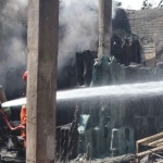 Petugas saat melakukan pemadaman api yang menghanguskan gudang plastik di Jombang.