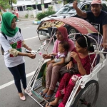 Aksi bagi-bagi bunga mawar di Simpang Empat Taman Kebon Rojo, Jombang. foto: RONY S/ BANGSAONLINE