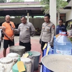 Tersangka S berusia 61 tahun (baju oranye) menunjukkan sejumlah barang yang dipergunakan untuk memproduksi miras ilegal, pada saat jumpa pers di Mapolsek Gedangan, Kabupaten Malang, Jawa Timur. Foto: Humas Polres Malang