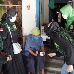 Srikandi GPK Jombang saat membagikan sembako kepada salah satu lansia.