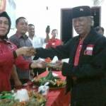Ketua DPC PDIP Gresik, Ir. Hj Siti Muafiyah menyerahkan potongan tumpeng kepada sesepuh PDIP Gresik. foto: SYUHUD/ BANGSAONLINE