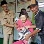 Belasan janda dan warga miskin saat menerima dana sosial BUMDes. foto: AAN AMRULLOH/ BANGSAONLINE