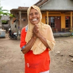 Boniyem (73) tersenyum bahagia setelah mendapat bantuan bahan bangunan semen dari SIG untuk memperbaiki rumahnya yang rusak akibat gempa. Foto: Ist
