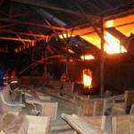 Dua karyawan menyaksikan gudang mebel mereka yang terbakar. foto: eki nurhadi/BANGSAONLINE