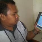 Ketua Panwas Lamongan Toni Wijaya menunjukkan bukti SMS yang dikirim oleh Kepala Dispenda Lamongan, Mursid.Foto:Azharil Farih/BANGSAONLINE
