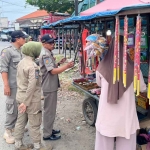 Petugas dari Satpol PP Kabupaten Mojokerto saat memantau penjual makanan-minuman, serta petasan di bagian utara Sungai Brantas.
