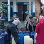Kapolsek Kejayan AKP Marti saat membagikan air bersih kepada warga.