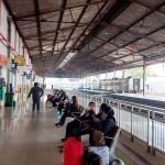 Para penumpang sedang menunggu kereta api di Stasiun Madiun.