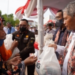 SVP of Supporting SIG Muchamad Supriyadi (kanan) menyerahkan paket sembako murah kepada warga Rembang pada acara Pasar Murah dan Bazar UMKM BUMN di Alun-Alun Rembang, Jawa Tengah. Foto: Ist.