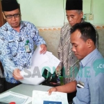 Salah satu CJH saat mengurus BAP di Kemenag Jombang, Senin (17/7/2017) didampingi Kasi Penyelenggaraan Haji dan Umroh Kemenag Jombang, Nur Habib Adnan. foto: ROMZA/ BANGSAONLINE