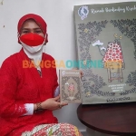 Salah satu penulis buku Rumah Berdinding Kisah, Triana Damayanti, saat menunjukkan bukunya ketika Malam Sastra Perlima, Sabtu (13/8/2022). Foto: Mustain/BANGSAONLINE