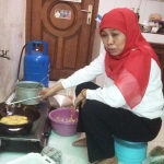 Khofifah Indar Parawansa sedang memasak di rumah.