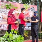 Ketua DPC PDIP Kediri Murdi Hantoro (kanan), menyerahkan secara simbolis bibit pohon kepada kader PDI Perjuangan untuk selanjutnya ditanam di area Sumber Petuk Telogo Agung, Minggu (23/1). foto: ist.