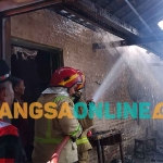 Para petugas Damkar Kabupaten Madiun saat memadamkan api yang membakar pabrik kerupuk. Foto: HENDRO SUHARTONO/BANGSAONLINE