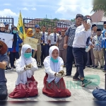 Aksi teatrikal yang digelar para aktivis PMII di depan gerbang Utara gedung DPRD Kabupaten Blitar.