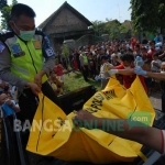 Petugas saat mengevakuasi jasad Musolin (54) yang ditemukan di ladang jagung di Dusun Kandangan, Desa Kepuhkembeng, Kecamatan Peterongan, Minggu (20/11). foto: RONY SUHARTOMO/ BANGSAONLINE