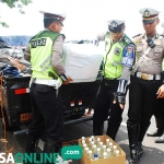 Kanit Patroli saat mengngecek botol yang berisi miras. foto: ZAINAL ABIDIN/ BANGSAONLINE