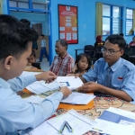 Petugas saat melayani penerima bantuan untuk melakukan aktivasi dan diberikan buku tabungan di Aula Dinas Sosial Kota Kediri, Kamis (6/6/2024).
