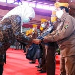 Gubernur Khofifah didampingi Kepala Biro Kesejahteraan Sosial Jatim Hudiono saat memberikan bingkisan. (foto: ist)