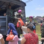 Petugas Satgas Bencana Banjir Pangkalan Utama TNI AL V (Lantamal V) Koarmada ll saat membagikan bahan kontak.