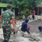 Anggota Babinsa Koramil Bringin, Sertu Suyono saat melakukan kerja bakti bersama warga setempat untuk pemasangan paving di blok sepanjang 500 meter.