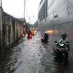 Pengendara menuntun motornya yang mogok setelah melintasi banjir di Jl Mambang, Kelurahan Pucang, Jumat (5/2). foto: nanang ichwan/ BANGSAONLINE