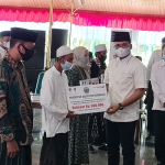 Bupati Bangkalan R. Abdul Latif Imron saat menyerahkan bantuan secara simbolis kepada guru madin.