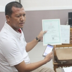 Kepala Dispendukcapil Kabupaten Pasuruan Yudha Tri Widya Sasongko menunjukkan berkas warga yang mengajukan pembaruan Kartu Keluarga (KK).