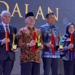 Sekdakot Mojokerto (paling kanan) mewakili Pj Wali Kota Mojokerto saat menerima penghargaan sebagai pembina koperasi andalan dalam acara peringatan Hari Koperasi Indonesia ke-77. 