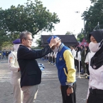Rektor Unirow Tuban Dr. Warli saat memakaikan identitas KKN kepada perwakilan mahasiswa. Foto: Ist.