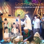 Bu Nyai Faridah saat menerima cenderamata berupa lukisan keluarga besarnya dari Ikapete Surabaya. 