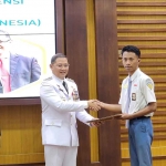 Kepala Dindik Jatim, Aries Agung Paewai, saat menyerahkan sertifikat uji kompetensi bertaraf nasional sesuai KKNI kepada salah satu pelajar.