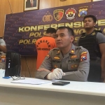 Pelaku pembacokan diapit oleh Kapolsek Wonocolo Kompol M. Sholeh dan Kasi Humas Polrestabes Surabaya AKP Haryoko Widi.